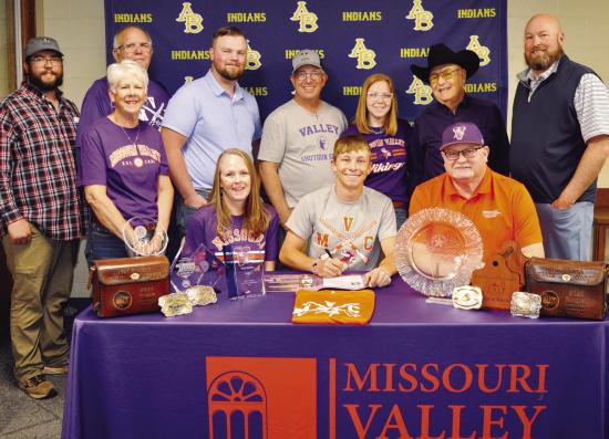 Nate Hickey, seated at center, signs his National Letter of Intent to compete in shooting sports for Missouri Valley College. Seated with him, from left, are his mother Erin Hickey, MVC coach Shawn Dulohery; standing, Mitchell Hunter, his grandmother Nanc