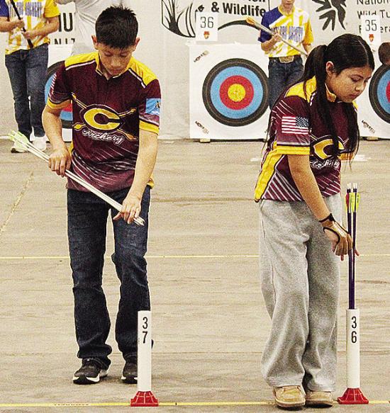Clinton seventh-graders Caleb Lopez, left, and Hayda Jimenez-Ramos set up their arrows during Grand State Archery last week in Tulsa. CDN | Courtesy photo