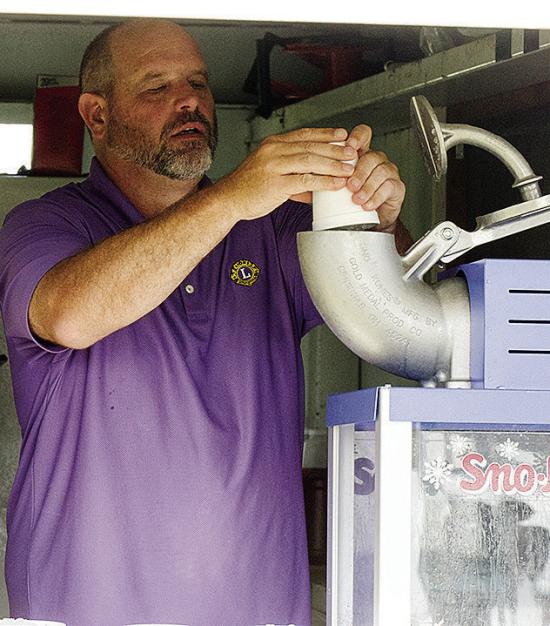 Brett Brittain fills the snow cone maker in the concession stand between the T-Ball fields during the Noon Lions games at Acme Brick Park. CDN | Sam Goodwyn