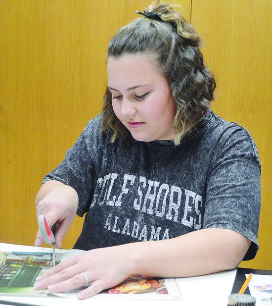 Karleigh James cuts out scraps from an old magazine to put on her 2026 vision board during an activity Monday evening at the Clinton Public Library. CDN | Micah Ashcraft Karleigh James cuts out scraps from an old magazine to put on her 2026 vision board during an activity Monday evening at the Clinton Public Library. CDN | Micah Ashcraft