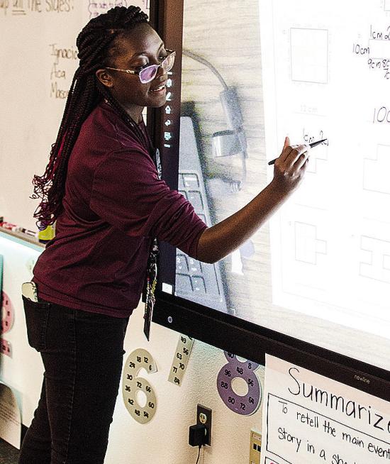 Jessica Jefferson writes on the smart board as she teaches math during school at Southwest Elementary School. CDN | Sam Goodwyn