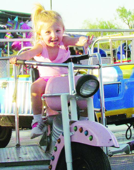 Andee Crumley rolls on her motorcycle in a “Cars” themed ride at last weekend’s Spring Carnival in Acme Brick Park. CDN | Christian Jacobsen