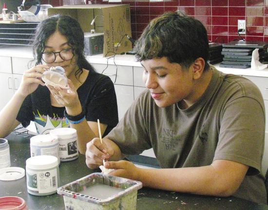 Valerie Pilloc, left, and Santiago Rodriguez Morquecho work on their big mouth art sculptures in class Tuesday at Clinton Middle School. CDN | Christian Jacobsen