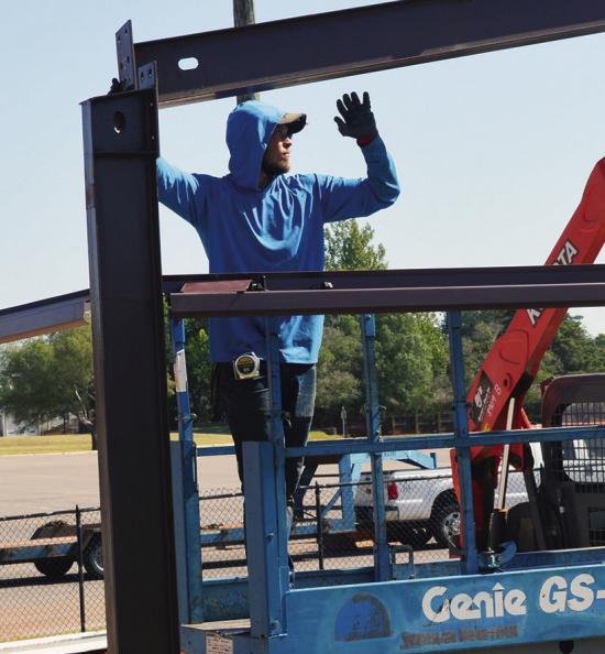Drake Carnes lines up the frame of the new equipment shed Tuesday at Clinton High School near the weight room and track. CDN | Christian Jacobsen Drake Carnes lines up the frame of the new equipment shed Tuesday at Clinton High School near the weight room and track. CDN | Christian Jacobsen