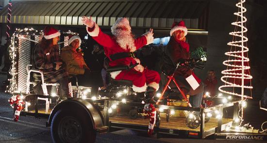 From left, Emily Weixel, Aaron Reyes, Cody Gore, and Terri Harrelson with Priority Home Medical Equipment wishes everyone a Merry Christmas from the back of their float in the Clinton Festival of Lights Christmas Parade. CDN | Micah Ashcraft