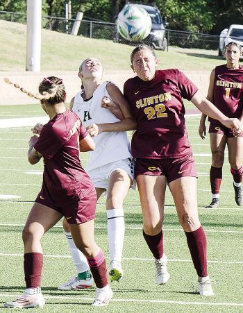 Clinton’s Aaliyah Lopez, right, heads the ball to her teammate Sammy Meraz, left, while fighting off the Harding Charter defender during the Lady Reds’ blowout win Monday at home over the Lady Eagles. CDN | Sam Goodwyn