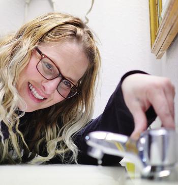 Kody Thompson sets the bathroom faucet to a drip Friday morning in one of the guest rooms at Days Inn in expectation of today’s frigid temperatures. CDN | Micah Ashcraft