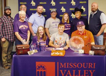 Nate Hickey, seated at center, signs his National Letter of Intent to compete in shooting sports for Missouri Valley College. Seated with him, from left, are his mother Erin Hickey, MVC coach Shawn Dulohery; standing, Mitchell Hunter, his grandmother Nanc